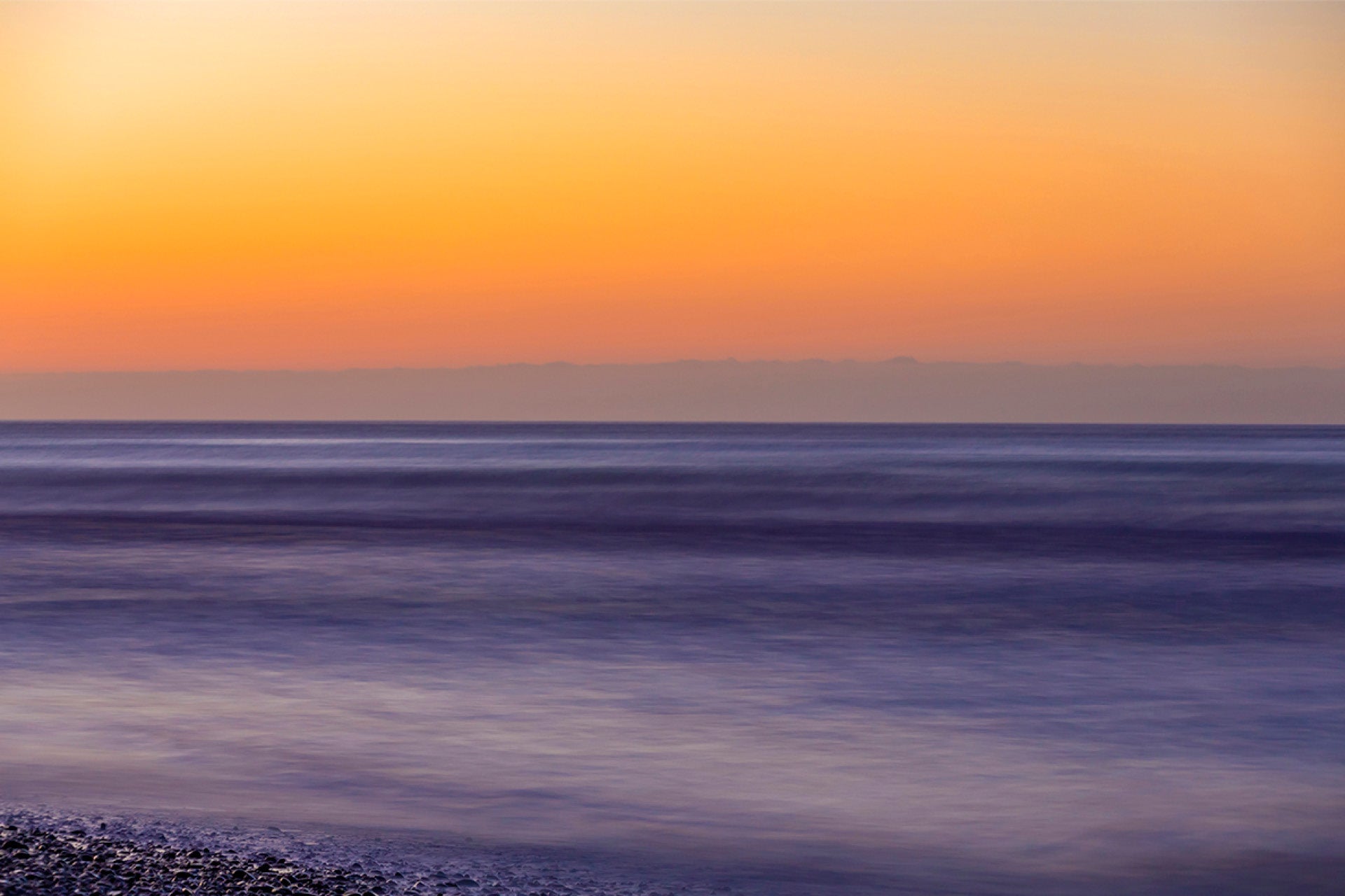 Gentle last light embracing Okarito Lagoon on New Zealand's West Coast in a captivating long-exposure beach vista, where serenity meets artistry, captured by photographer Steve Couper – perfect for twilight enthusiasts seeking Aotearoa's peaceful beauty.