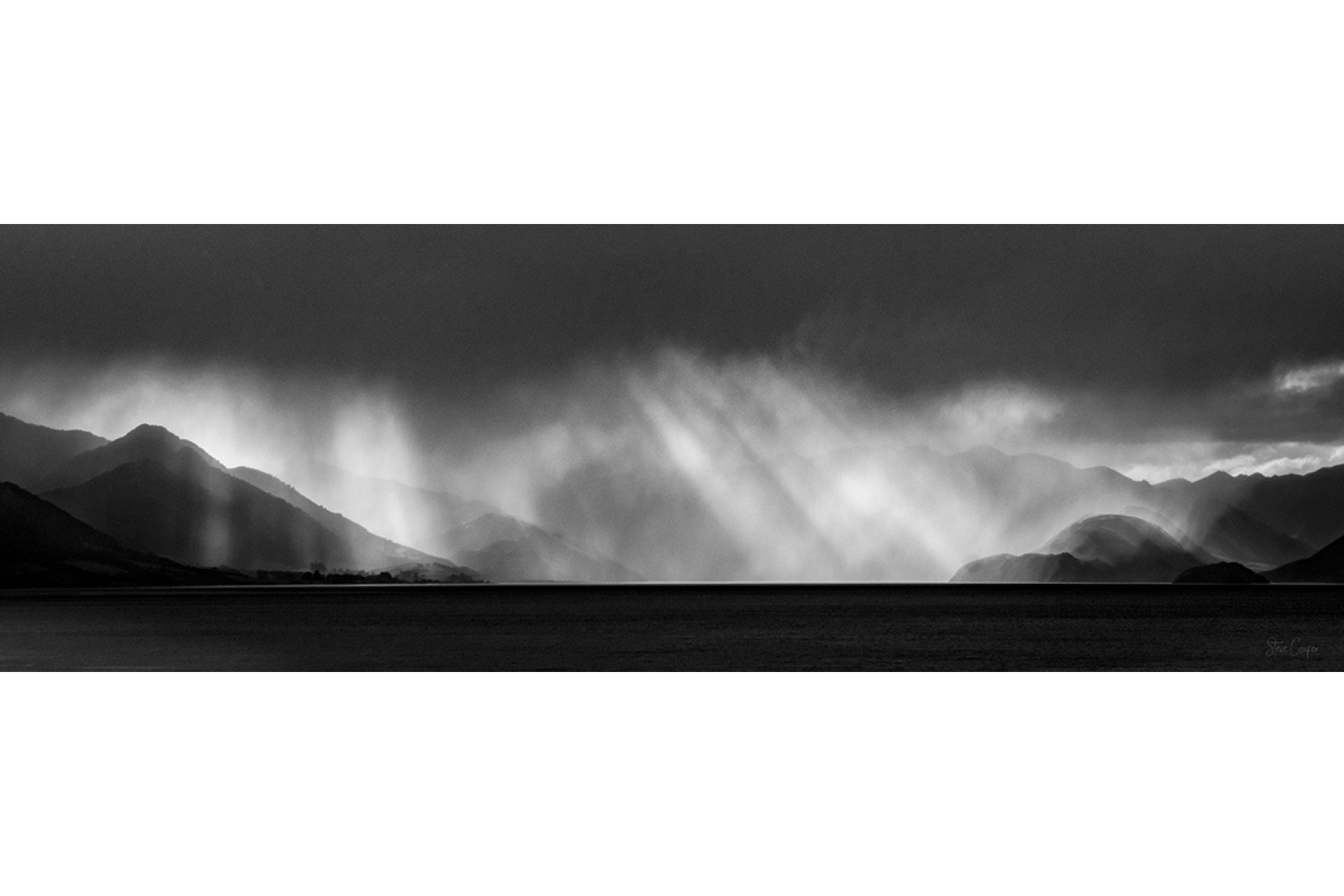 Dazzling sunburst over Lake Hawea South Island New Zealand, with golden rays piercing mountain silhouettes and reflecting on pristine glacial waters in the Southern Alps

