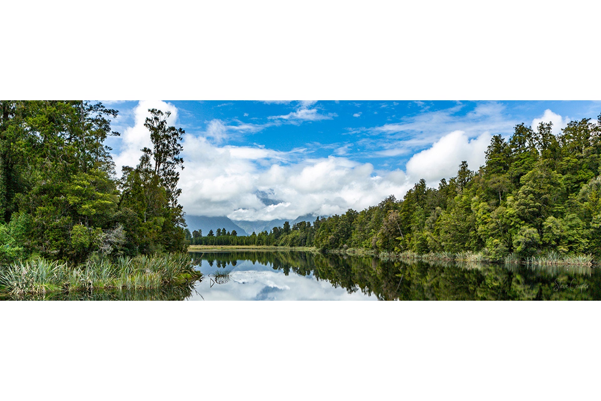 Timeless reflections of Aoraki Mt Cook in Lake Matheson West Coast South Island New Zealand, with snow-capped peaks mirroring in calm waters amid ancient rainforests at dawn
