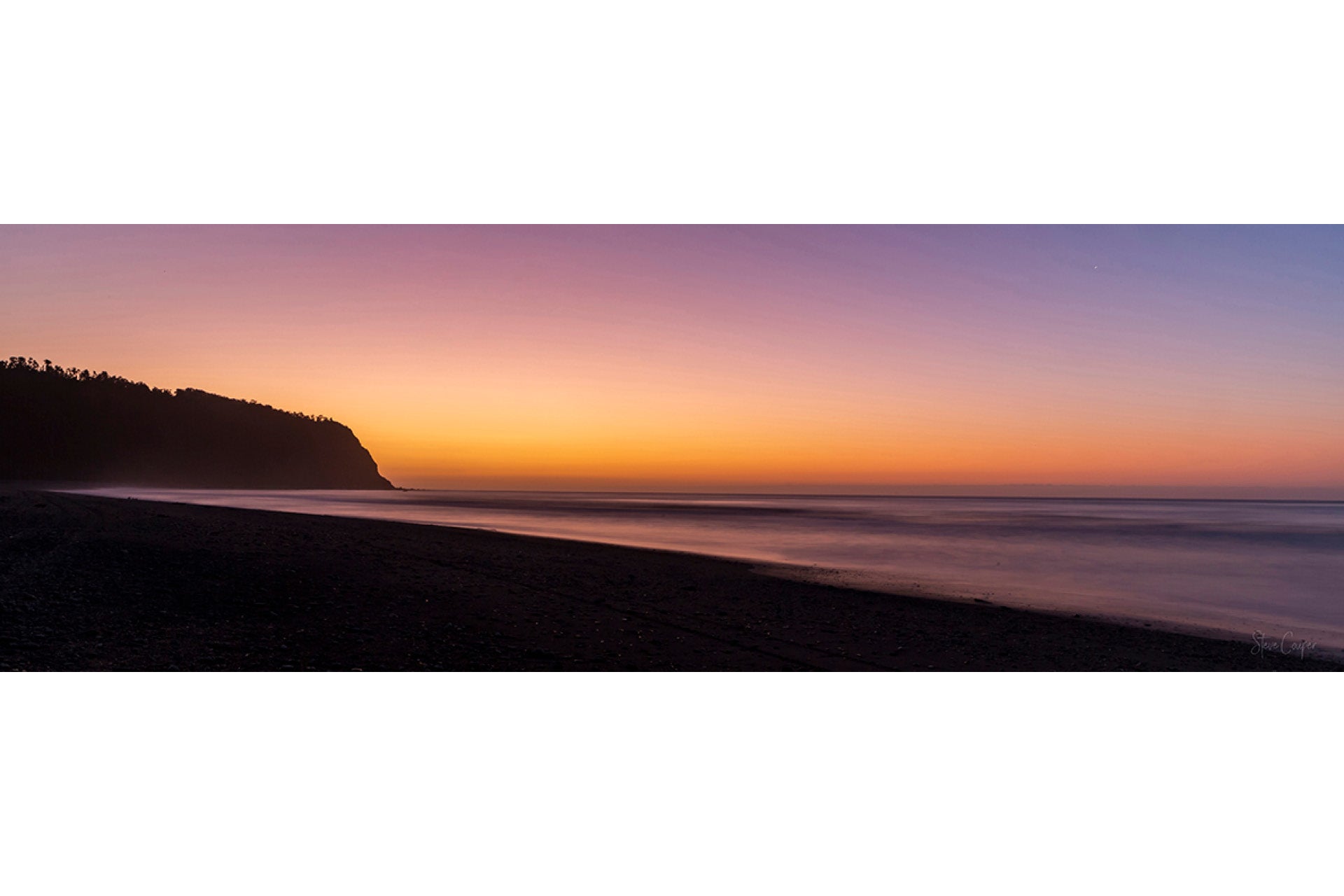 Mesmerising long exposure sunset at Okarito Beach on New Zealand's West Coast South Island, with silky waves, sandy shores, ancient forests, and glowing horizons
