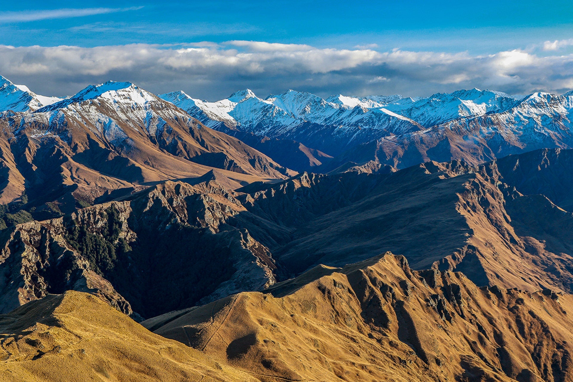 Classic view from Skippers Saddle, Queenstown, of northern mountains with low sun casting vibrant color, depth, and shadows in Central Otago, captured by photographer Steve Couper – ideal for explorers seeking Aotearoa's inviting beauty.