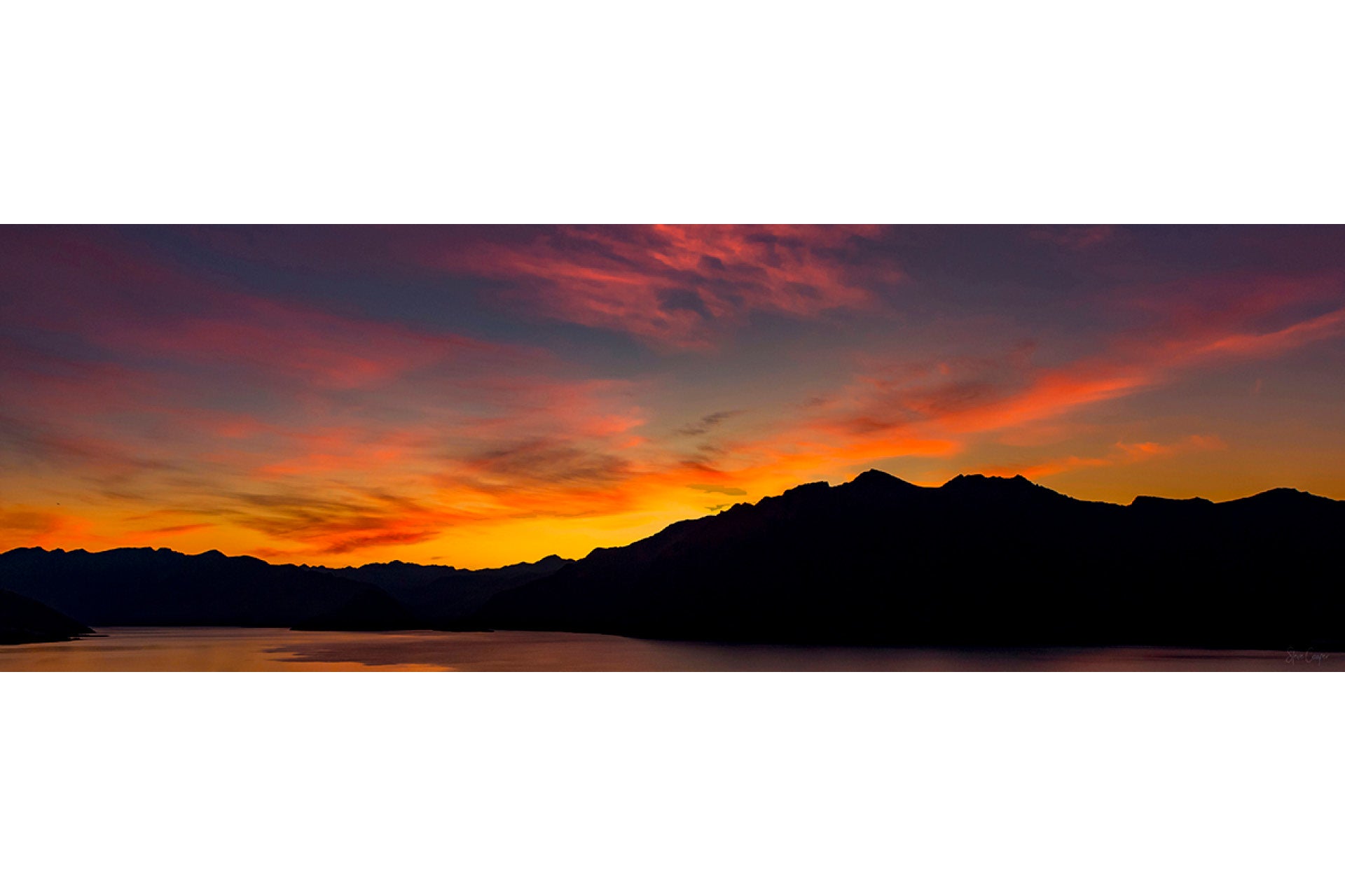 Tranquil sunrise over Lake Hawea in New Zealand's South Island, with soft golden light reflecting on pristine waters and surrounding Otago peaks